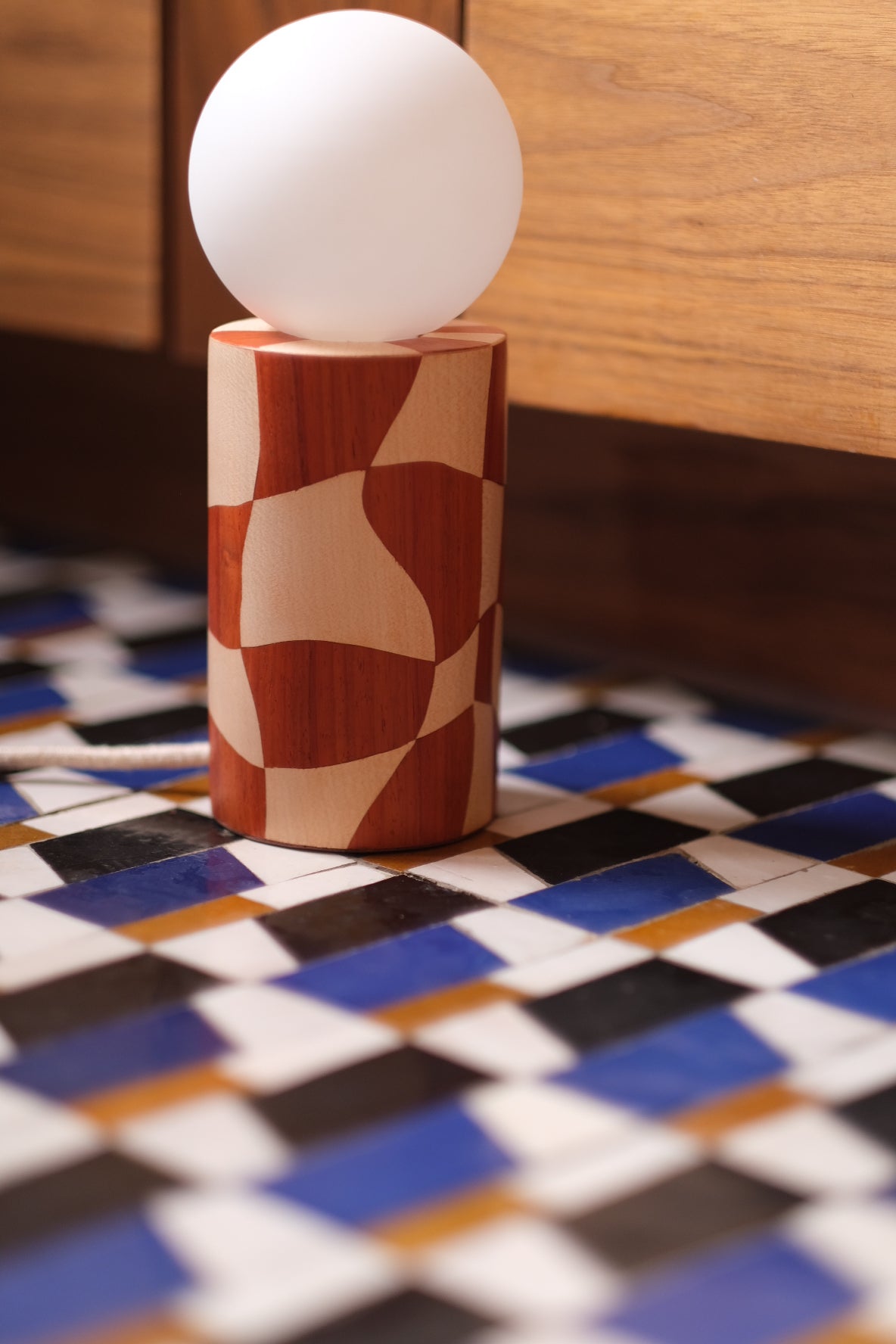 Lampe pion en marqueterie de bois pour Ome éditions. Damier en bois de padouk (bois rouge) et Sycomore (bois blanc). Pièce fabriquée à la main par Hermine Torikian, notre artiste ébéniste. Son atelier est à Paris.