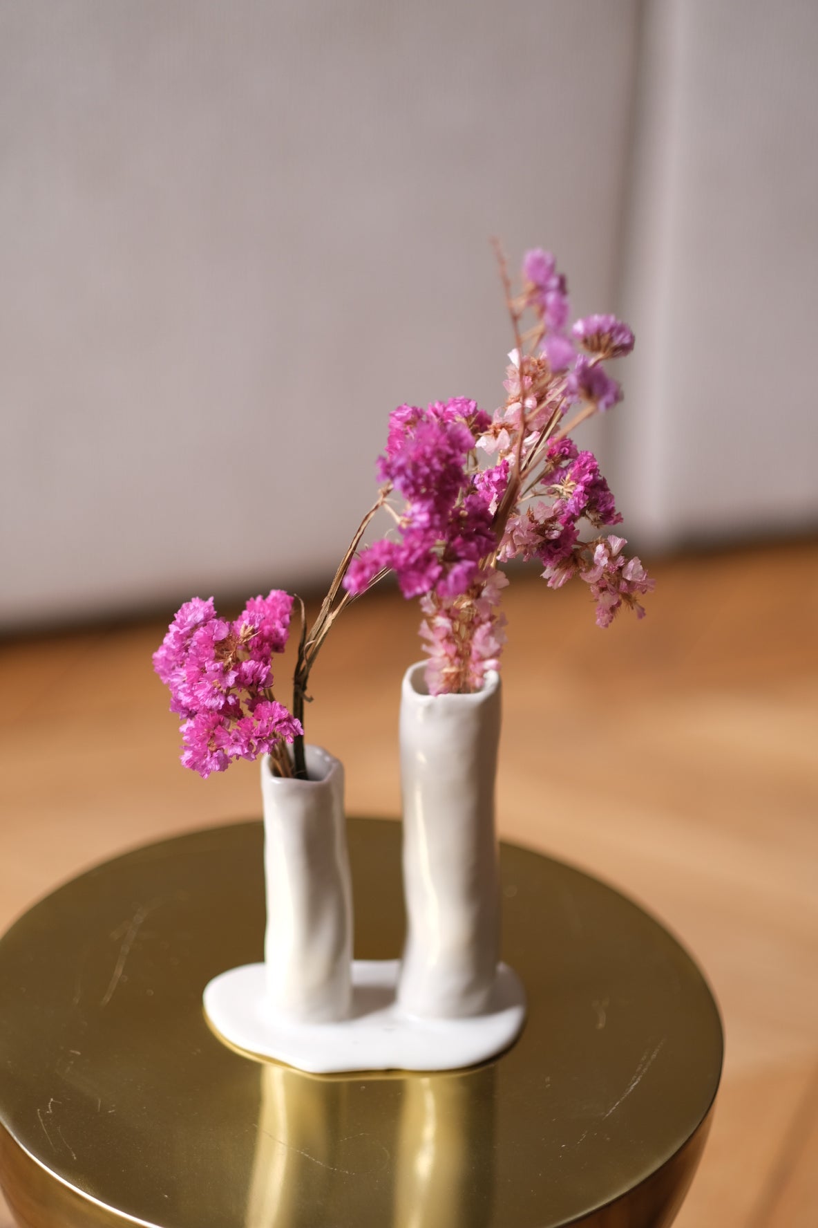 Soliflore en grès, fait à la main en région parisienne. Ikebana à deux fleurs nous charme par son aspect délicat et original. Décliné en deux couleurs très minérales (vert et blanc), l'Ikebana saura habiller vos consoles, étagères, cheminées, ou même en centre de table. Ici soliflore blanc sur une table basse. Email naturel.