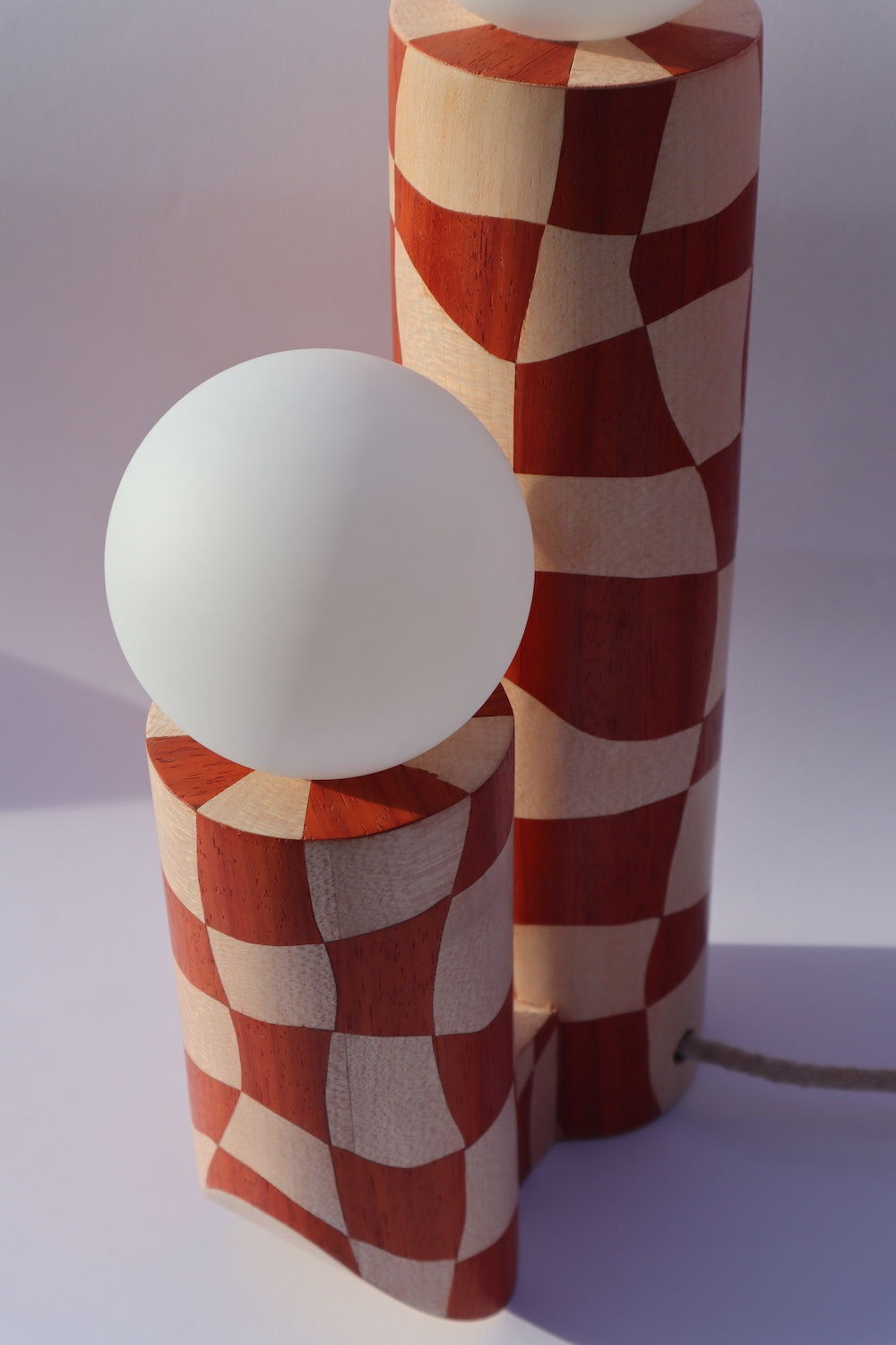 Lampe en marqueterie de bois et sa robe à carreaux pour Ome éditions. Damier en bois de padouk (bois rouge) et Sycomore (bois blanc). Pièce fabriquée à la main par Hermine Torikian, notre artiste ébéniste. Son atelier est à Paris. Lampe à poser sur une étagère, un table de chevet, dans une bibliothèque... Ici sur une commode