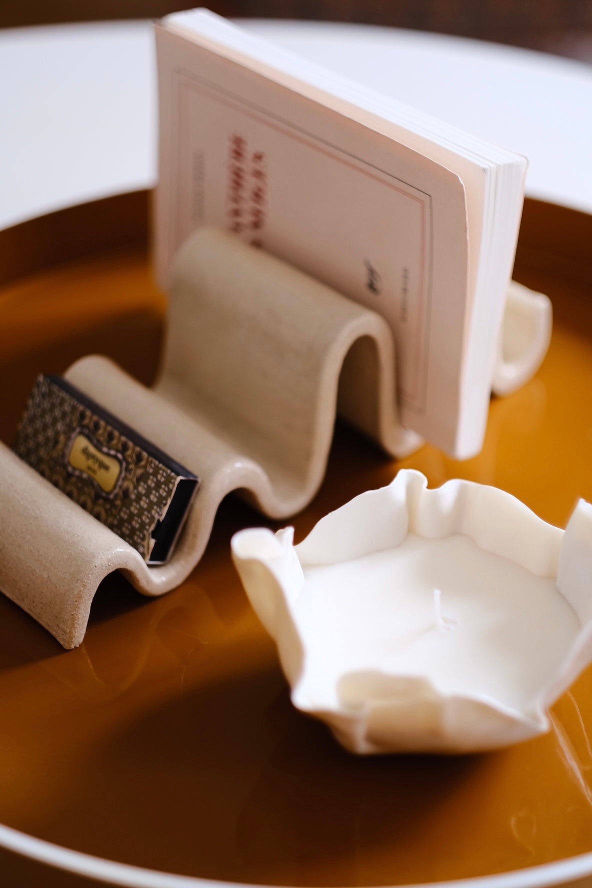 Vide-poche en forme de vague. Fait en grès blanc chamotté à Paris.Cette pièce artisanale et sculpturale, poétique, tout en rondeurs peut accueillir vos clés, pièces de monnaie... mais aussi des bijoux, votre courrier ou autres objets du quotidien. Ici sur un plateau, sur une table basse.