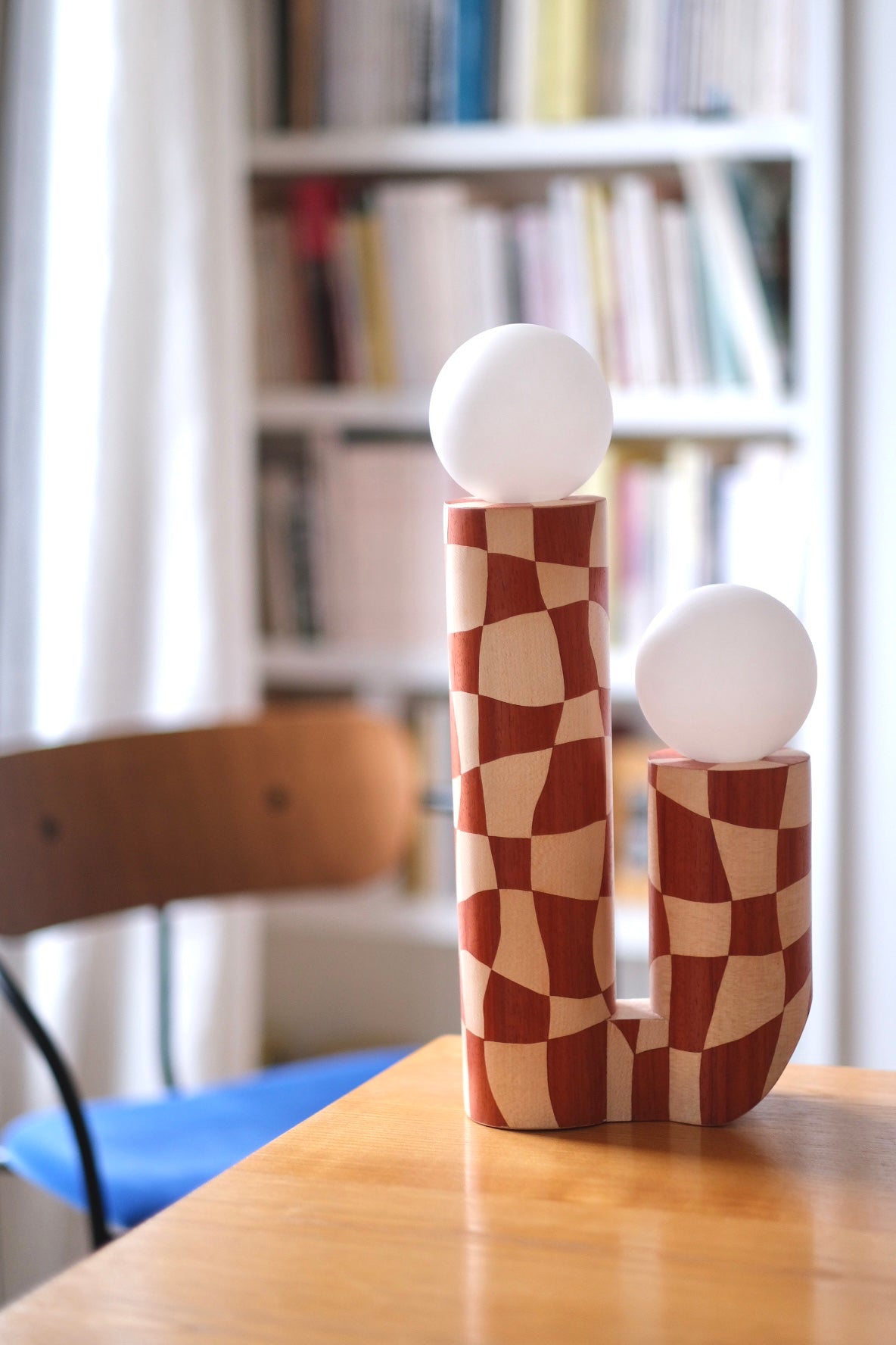 Lampe en marqueterie de bois et sa robe à carreaux pour Ome éditions. Damier en bois de padouk (bois rouge) et Sycomore (bois blanc). Pièce fabriquée à la main par Hermine Torikian, notre artiste ébéniste. Son atelier est à Paris. Lampe à poser sur une étagère, un table de chevet, dans une bibliothèque... Ici sur une table